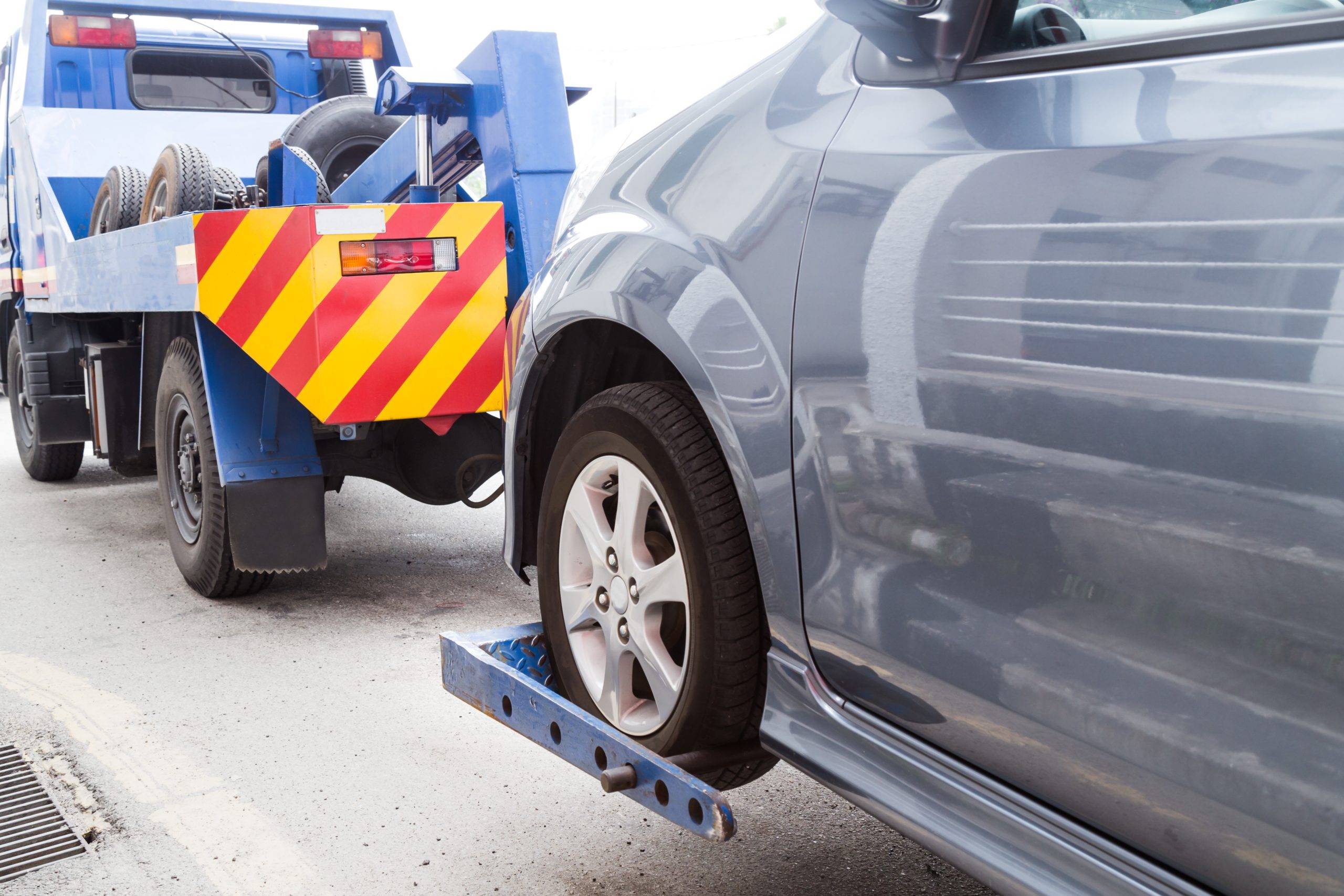 Tow Truck Towing A Broken Down Car On The Street